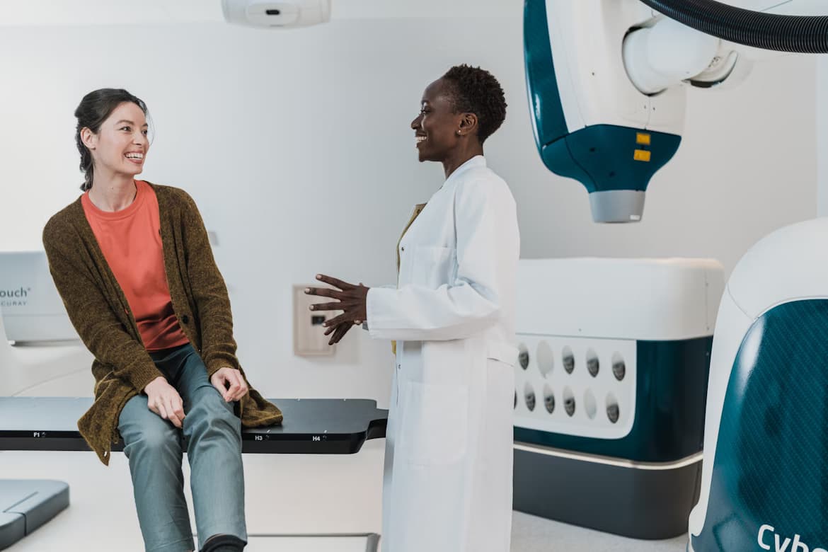 Doctor showing a patient a 3D model on a large screen